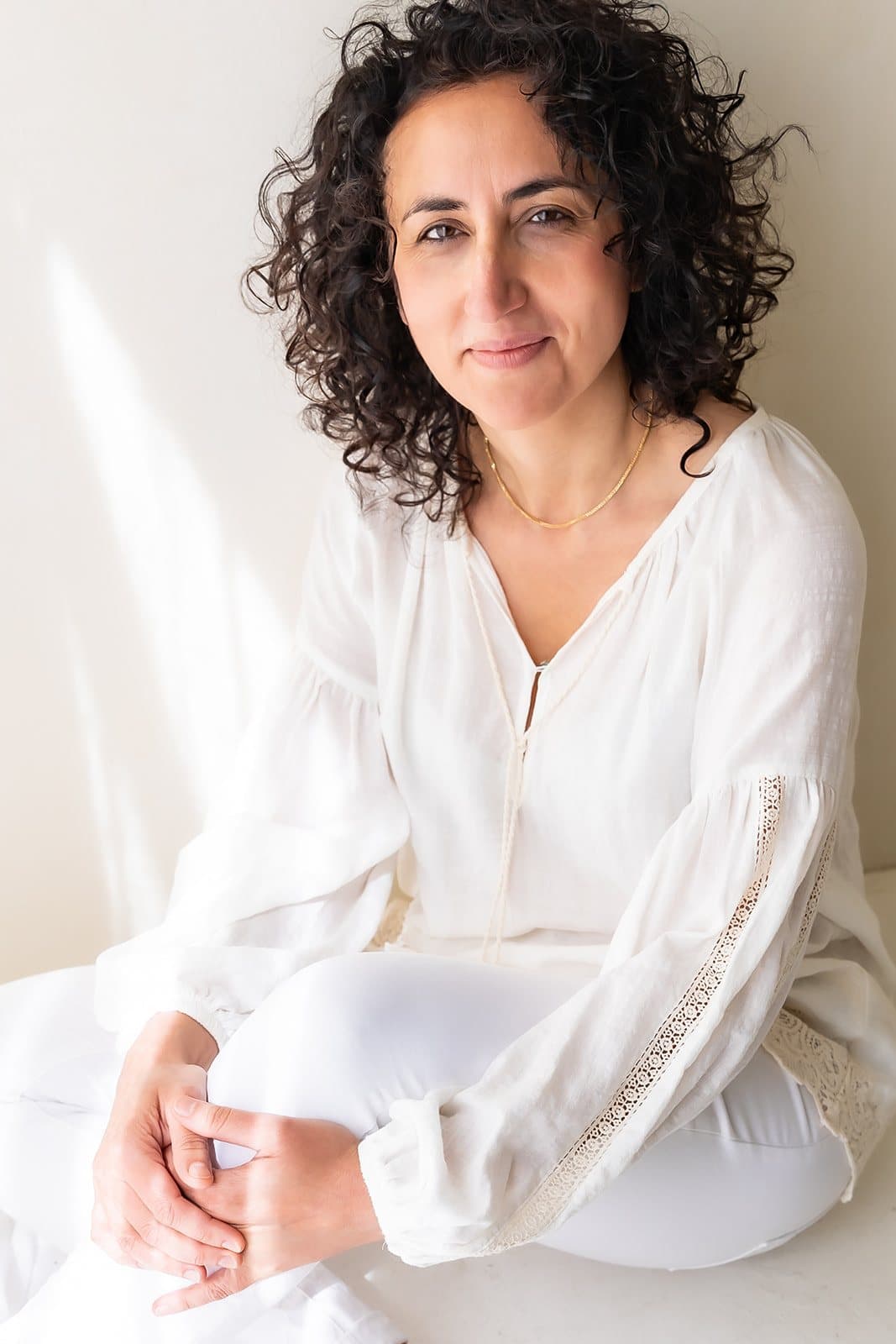 Sara Setodeh kijkt in de camera, zittend in een lichte ruimte